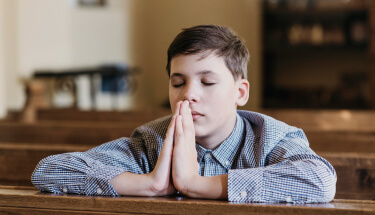 Little Boy Praying In The Church